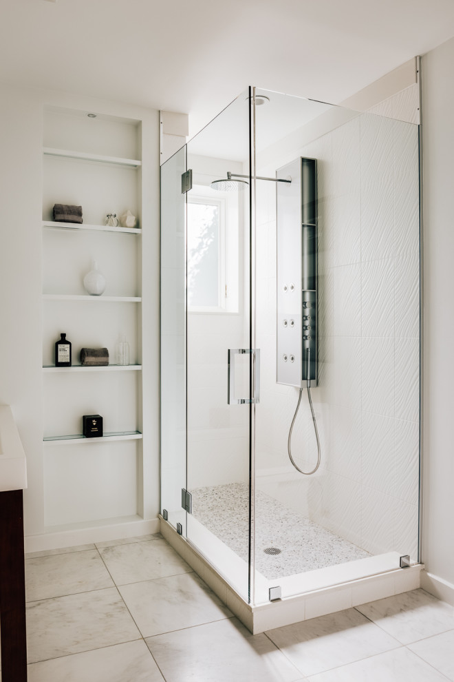 Design ideas for a mid-sized modern 3/4 bathroom in San Francisco with glass-front cabinets, brown cabinets, a freestanding tub, a corner shower, a two-piece toilet, white tile, ceramic tile, white walls, ceramic floors, a console sink, marble benchtops, beige floor, a hinged shower door, white benchtops, an enclosed toilet, a single vanity, a built-in vanity and panelled walls.