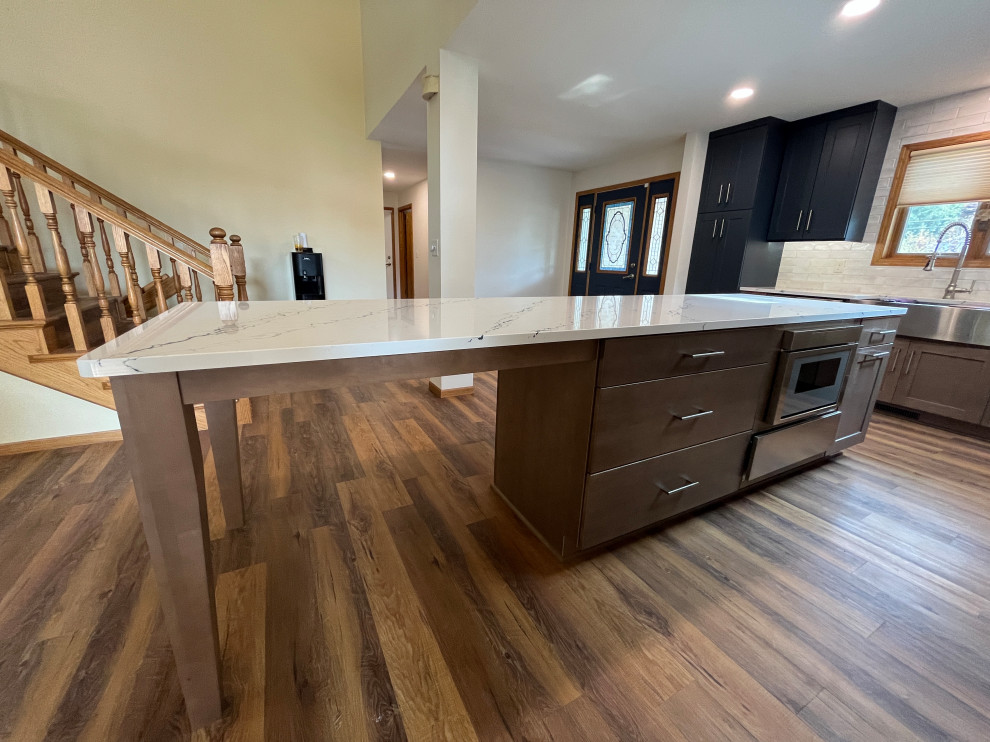 Large transitional l-shaped eat-in kitchen photo with shaker cabinets, quartz countertops and an island