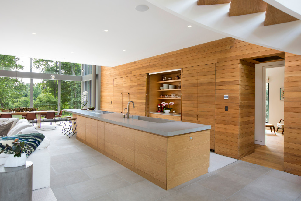 Design ideas for a mid-sized modern open plan kitchen in New York with an integrated sink, flat-panel cabinets, light wood cabinets, quartz benchtops, stainless steel appliances, limestone floors, with island, grey floor and grey benchtop.