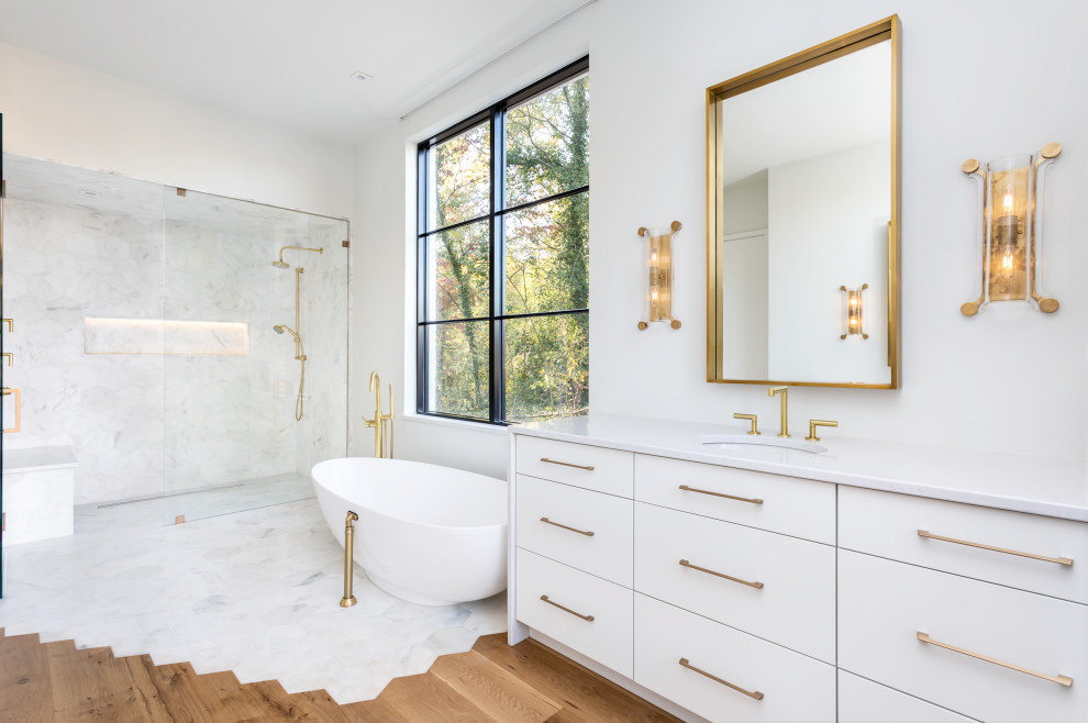 This is an example of a large contemporary bathroom in Other with flat-panel cabinets, white cabinets, a freestanding bath, a built-in shower, white walls, a submerged sink, a hinged door and white worktops.