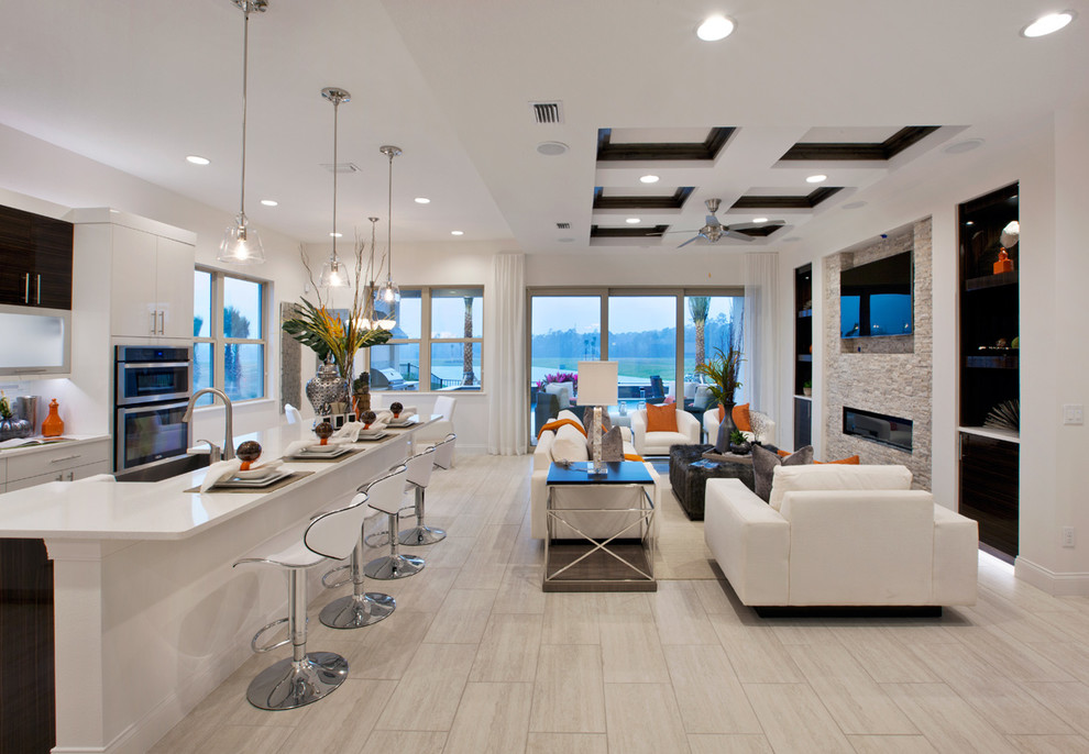 Photo of a large contemporary open concept living room in Miami with a home bar, white walls, light hardwood floors, a hanging fireplace, a stone fireplace surround and a wall-mounted tv.