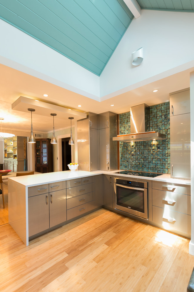 Photo of a mid-sized contemporary u-shaped kitchen in Charleston with flat-panel cabinets, grey cabinets, blue splashback, glass tile splashback, a single-bowl sink, stainless steel appliances and bamboo floors.