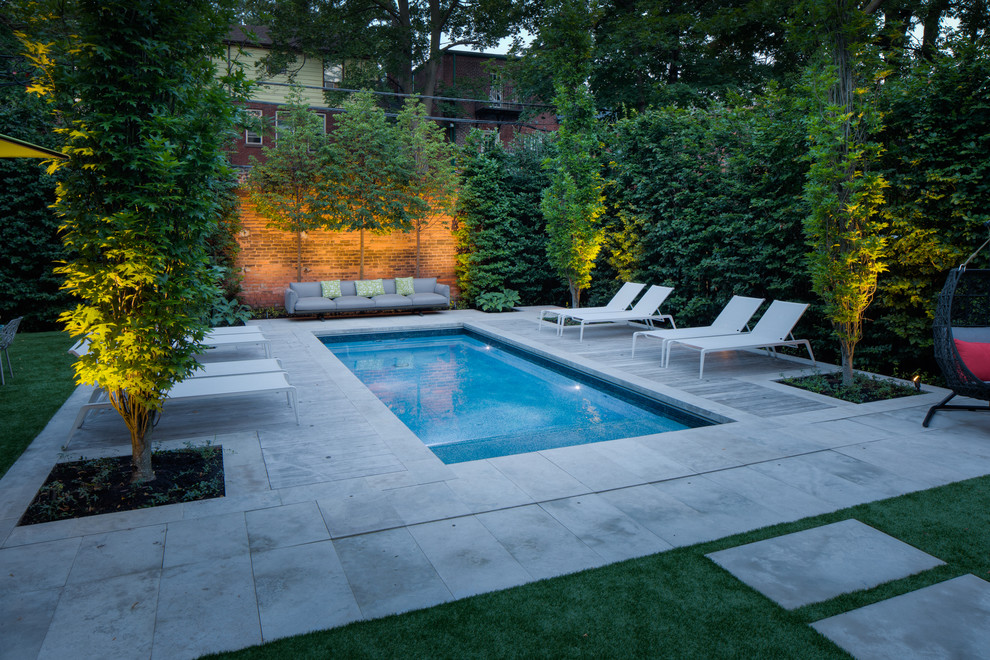 Design ideas for a small contemporary backyard rectangular pool in Toronto with natural stone pavers.
