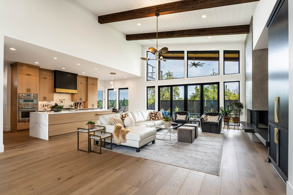 Inspiration for a contemporary open plan living room in Portland with white walls, medium hardwood flooring, a standard fireplace, brown floors, exposed beams, a timber clad ceiling and a vaulted ceiling.