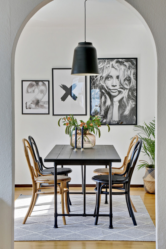 Contemporary dining room in Gothenburg with white walls, medium hardwood floors and brown floor.