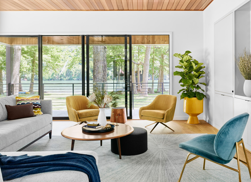 Living room - contemporary formal light wood floor and brown floor living room idea in Austin with white walls