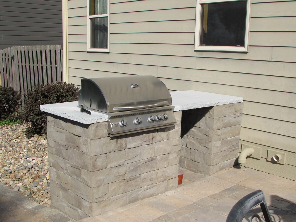 Inspiration for a large traditional backyard patio in Other with an outdoor kitchen, natural stone pavers and no cover.