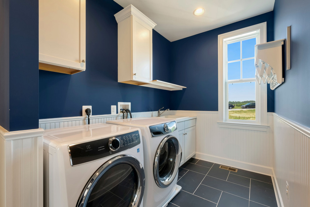 This is an example of a large country utility room in DC Metro with a drop-in sink, white cabinets, blue walls, a side-by-side washer and dryer, blue floor, white benchtop, shaker cabinets, laminate benchtops, laminate floors and panelled walls.