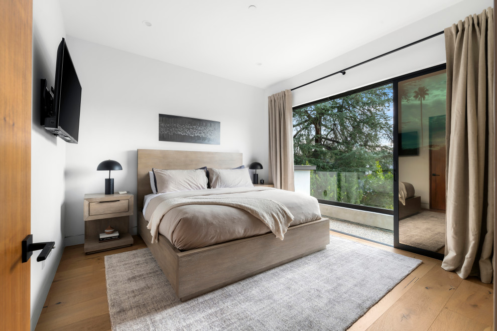 Modelo de habitación de invitados actual de tamaño medio con paredes blancas, suelo de madera clara y suelo beige