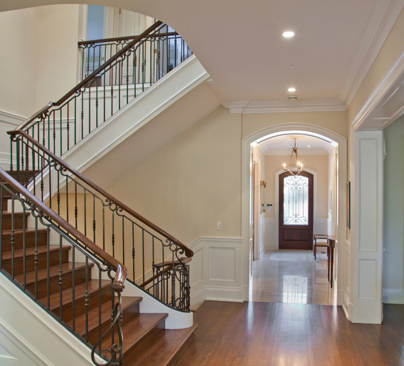 Inspiration for a mid-sized traditional wood u-shaped staircase in Toronto with wood risers and metal railing.