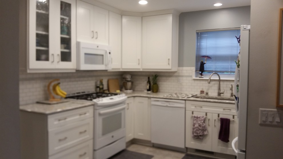 Small transitional u-shaped ceramic tile eat-in kitchen photo with an undermount sink, shaker cabinets, white cabinets, quartz countertops, white backsplash, subway tile backsplash, white appliances and no island