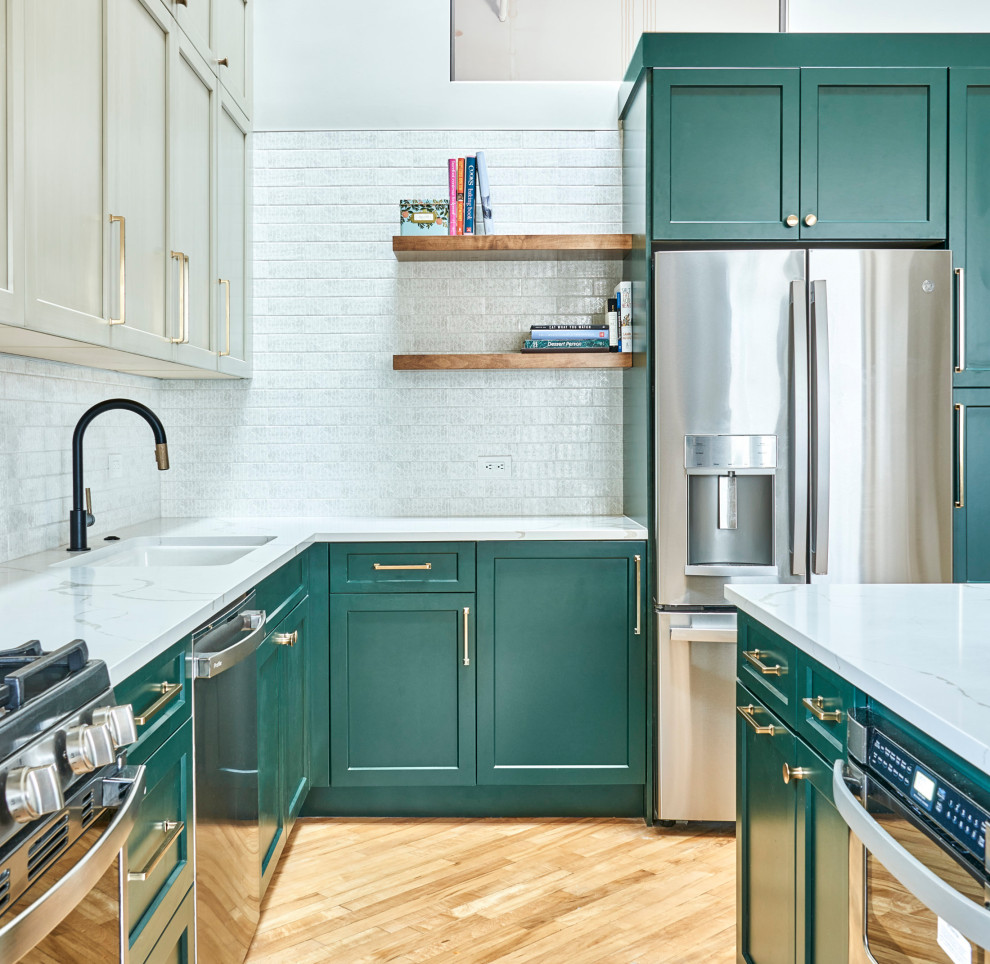 Example of a mid-sized urban l-shaped eat-in kitchen design in Chicago with an undermount sink, recessed-panel cabinets, green cabinets, quartzite countertops, white backsplash, subway tile backsplash, black appliances, an island and white countertops