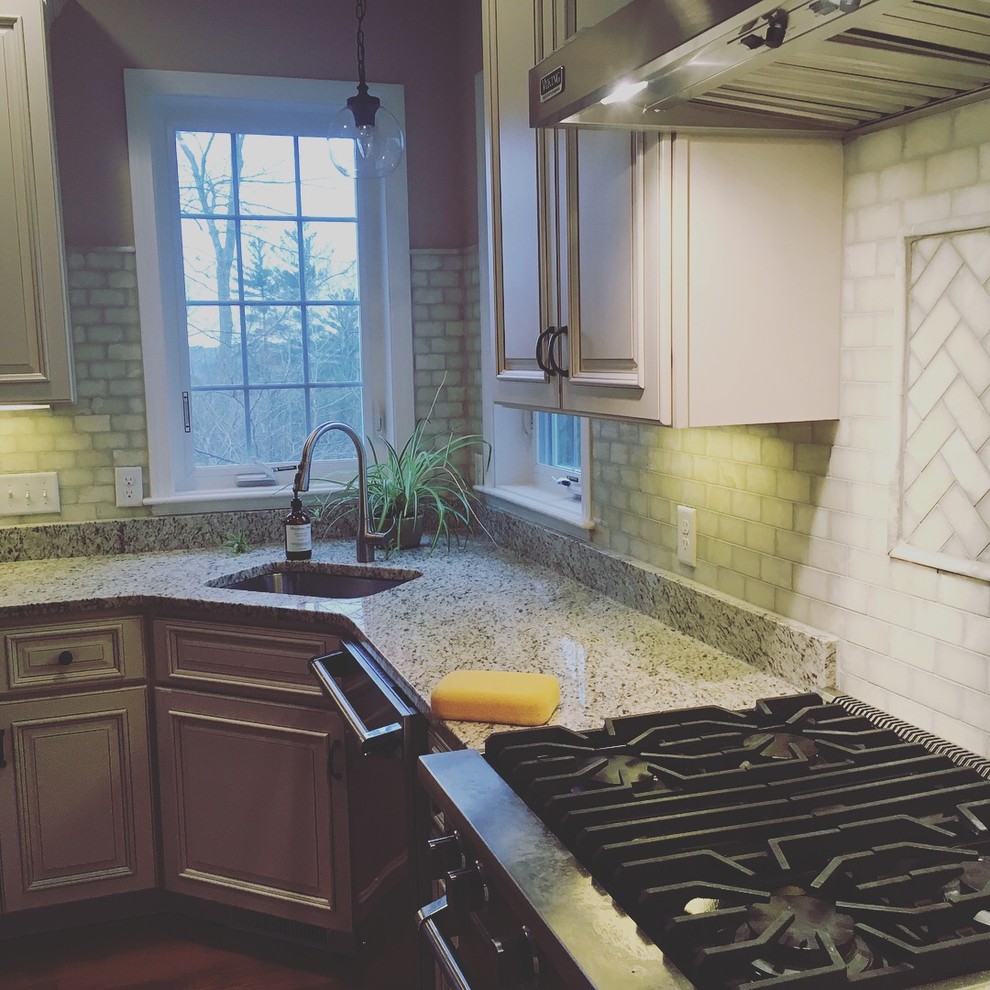 Example of a large transitional l-shaped kitchen design in Boston with an undermount sink, raised-panel cabinets, gray cabinets, granite countertops, gray backsplash, subway tile backsplash, stainless steel appliances and multicolored countertops