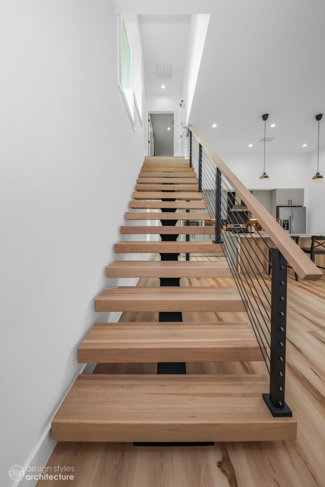 Пример оригинального дизайна: металлическая лестница на больцах, среднего размера в современном стиле с деревянными ступенями и деревянными перилами