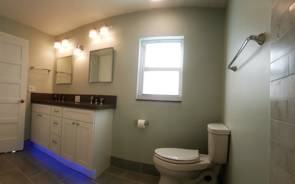 Transitional gray tile and marble tile porcelain tile corner shower photo in Miami with shaker cabinets, white cabinets, a two-piece toilet, green walls, an undermount sink and quartz countertops
