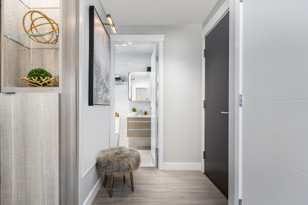 Photo of a small eclectic foyer in Calgary with grey walls, laminate floors, a single front door, a black front door and grey floor.