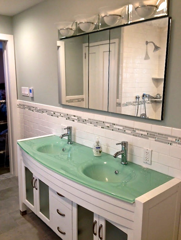 Design ideas for a mid-sized transitional 3/4 bathroom in Chicago with white cabinets, a shower/bathtub combo, blue tile, gray tile, white tile, subway tile, an integrated sink, glass benchtops, grey floor, furniture-like cabinets, a drop-in tub, white walls and turquoise benchtops.