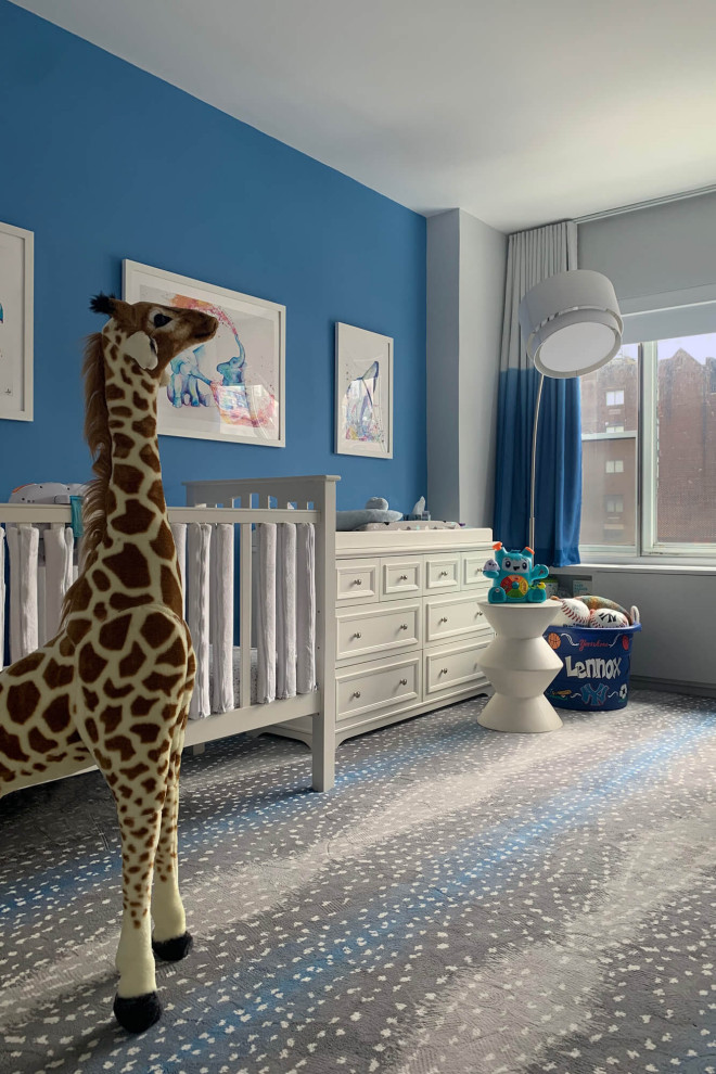 Inspiration for a mid-sized transitional nursery for boys in New York with blue walls, carpet and multi-coloured floor.