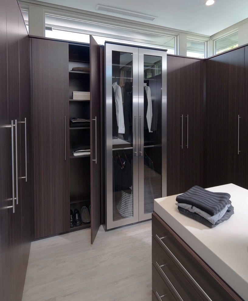 Photo of an expansive contemporary walk-in wardrobe in Sacramento with flat-panel cabinets, dark wood cabinets and porcelain floors.