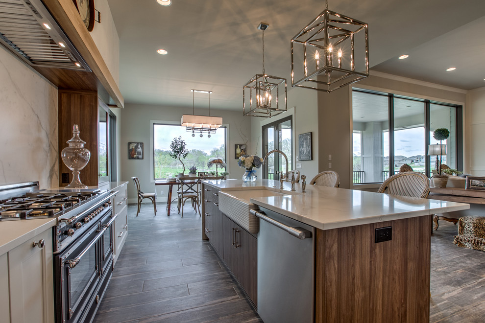 Large country l-shaped eat-in kitchen in Omaha with a farmhouse sink, quartzite benchtops, stainless steel appliances, porcelain floors, with island, white cabinets, white splashback, recessed-panel cabinets, ceramic splashback and grey floor.