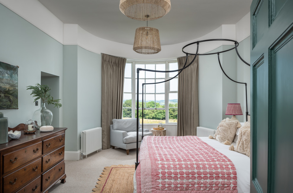 Large traditional master bedroom in Devon with blue walls, carpet and beige floors.