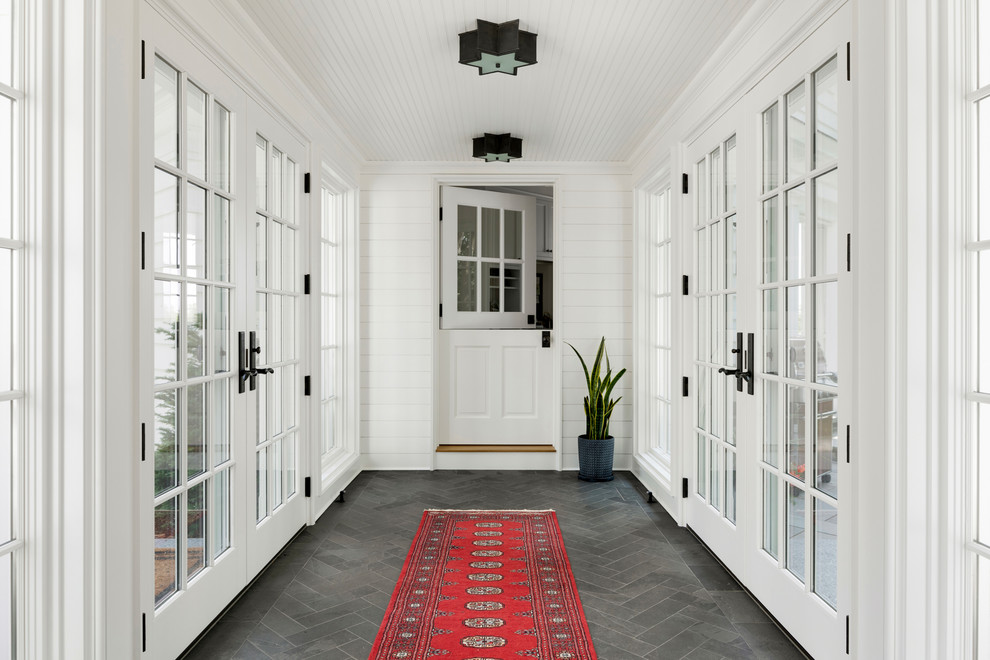 Design ideas for a beach style vestibule in Minneapolis with white walls, a dutch front door, a white front door and grey floor.