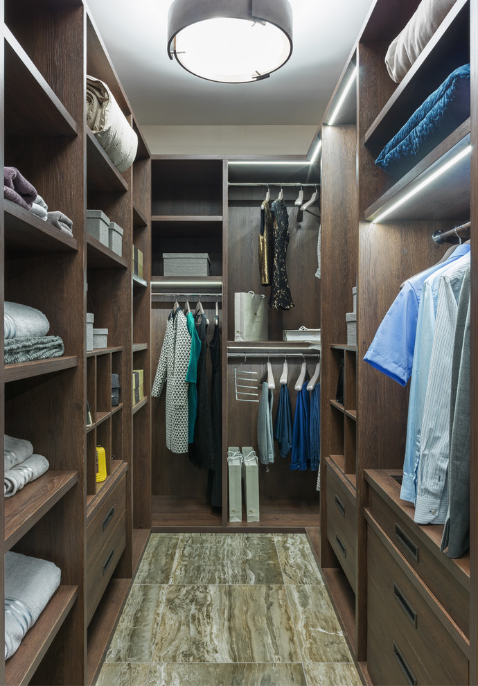 Photo of a contemporary gender-neutral walk-in wardrobe in Moscow with flat-panel cabinets and medium wood cabinets.