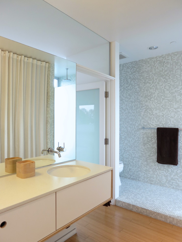 This is an example of a modern master bathroom in Los Angeles with an undermount sink, recessed-panel cabinets, white cabinets, engineered quartz benchtops, an open shower, white tile, mosaic tile, white walls and light hardwood floors.