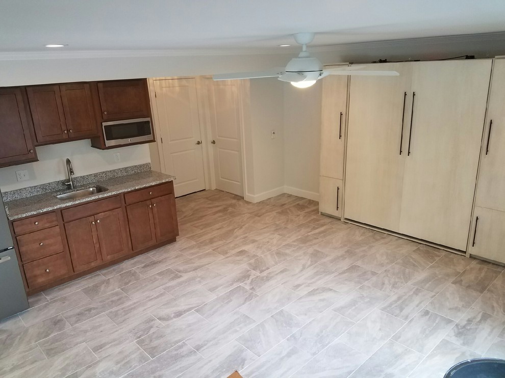 Example of a large transitional single-wall ceramic tile open concept kitchen design in Cincinnati with a drop-in sink, flat-panel cabinets, dark wood cabinets, granite countertops, stainless steel appliances and no island