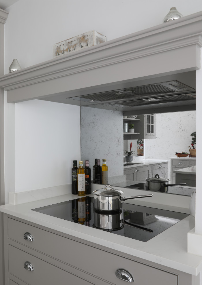 Inspiration for a mid-sized traditional u-shaped eat-in kitchen in London with an undermount sink, shaker cabinets, grey cabinets, quartzite benchtops, grey splashback, mirror splashback, black appliances, porcelain floors, with island, white floor and white benchtop.