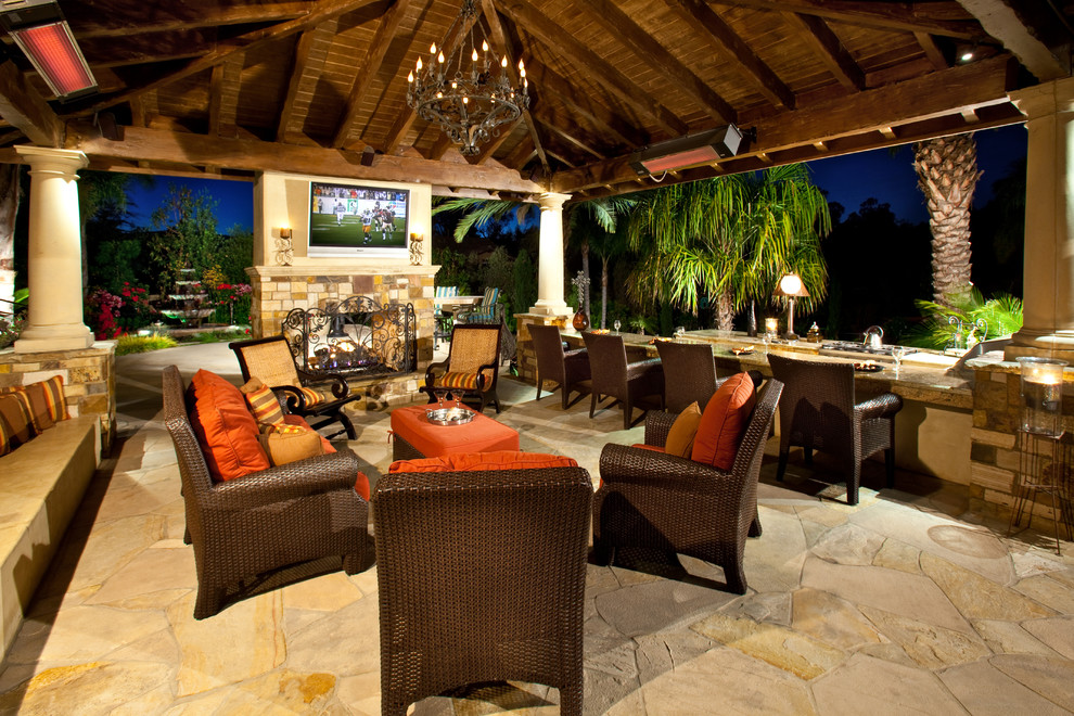 Photo of a tropical patio in Orange County with a fire feature.