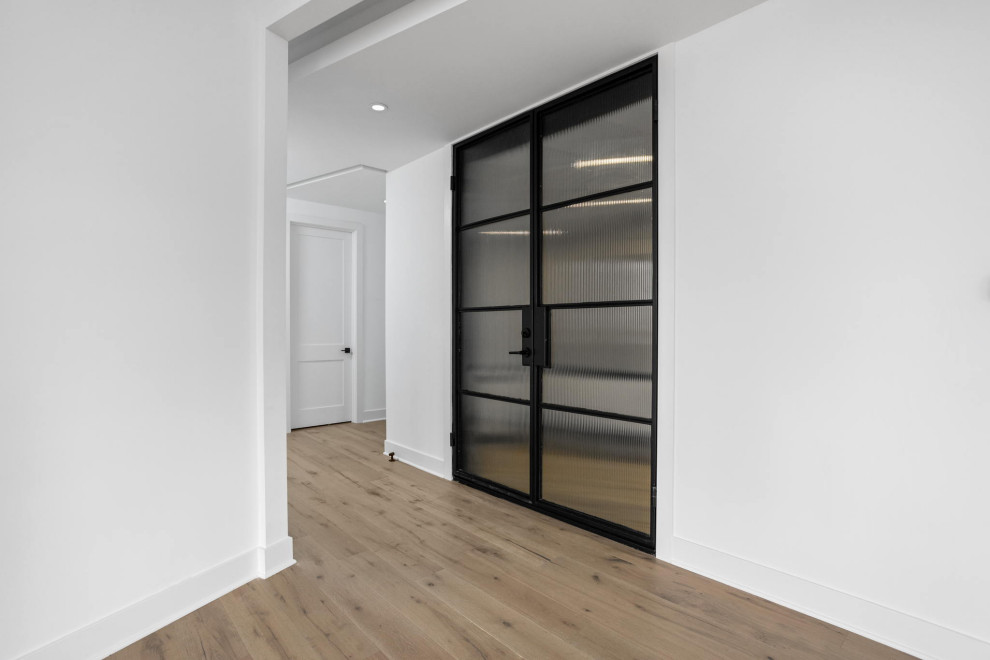 Foto de puerta principal actual de tamaño medio con paredes blancas, suelo de madera clara, puerta doble, puerta de vidrio, suelo multicolor y casetón