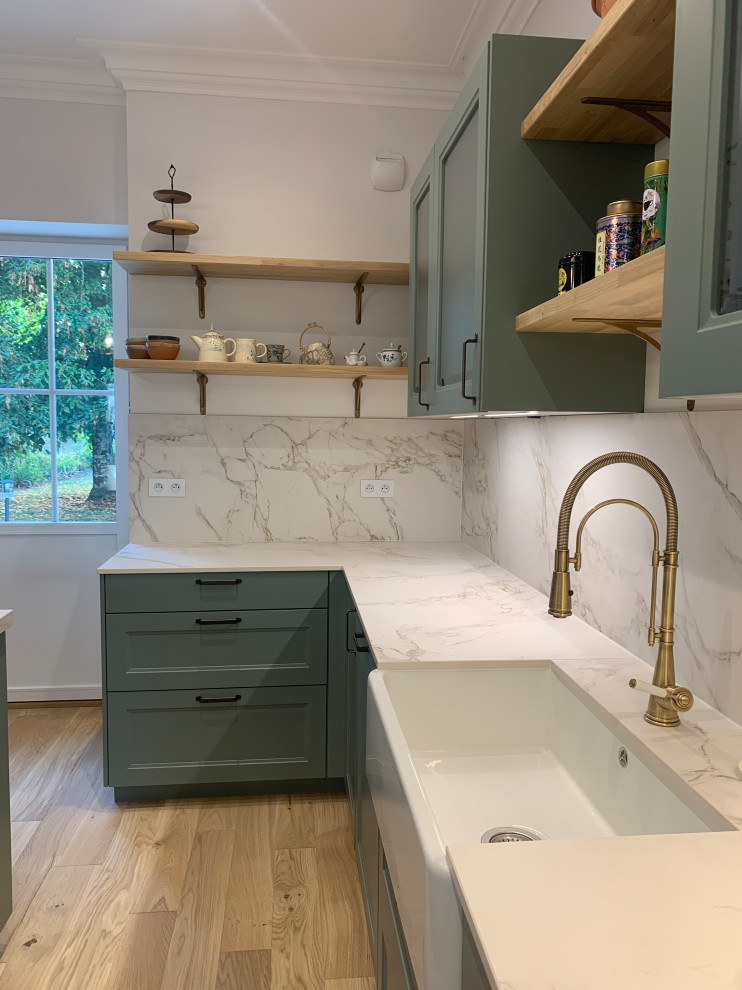 Inspiration for a medium sized farmhouse u-shaped kitchen/diner in Bordeaux with a belfast sink, shaker cabinets, green cabinets, marble worktops, white splashback, marble splashback, stainless steel appliances, light hardwood flooring, an island, beige floors, white worktops and exposed beams.