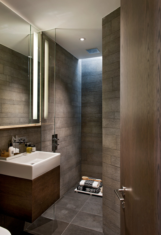 Photo of a contemporary bathroom in London with flat-panel cabinets, dark wood cabinets, an open shower, brown tile and an open shower.