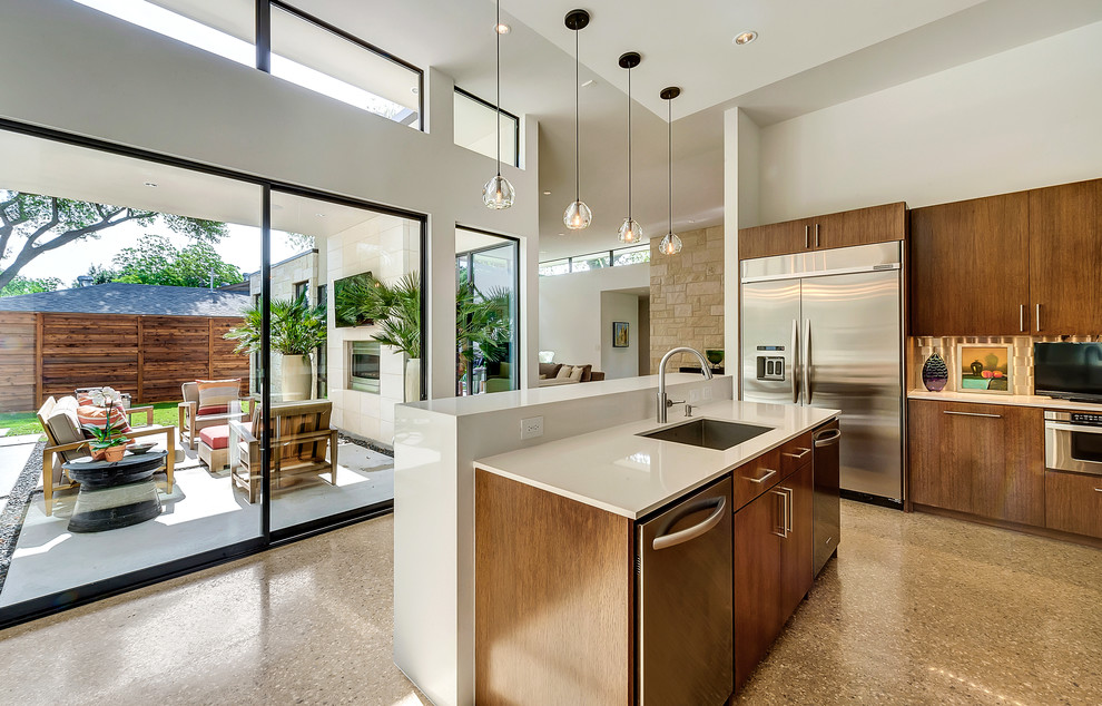 This is an example of a large modern u-shaped kitchen pantry in Dallas with an undermount sink, flat-panel cabinets, medium wood cabinets, quartz benchtops, multi-coloured splashback, glass tile splashback, stainless steel appliances, concrete floors and multiple islands.