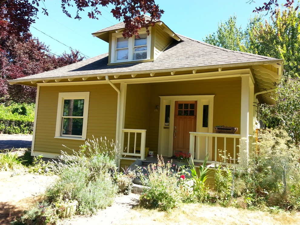 Design ideas for a small arts and crafts two-storey yellow exterior in Portland.