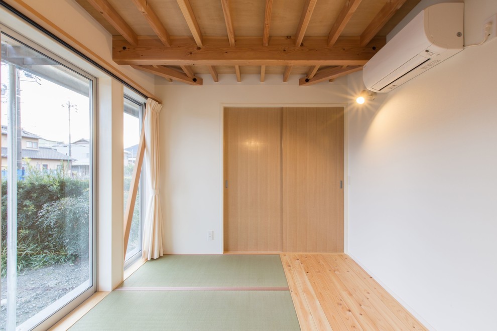 Idée de décoration pour une chambre parentale asiatique de taille moyenne avec un mur blanc, un sol de tatami, un sol vert et aucune cheminée.