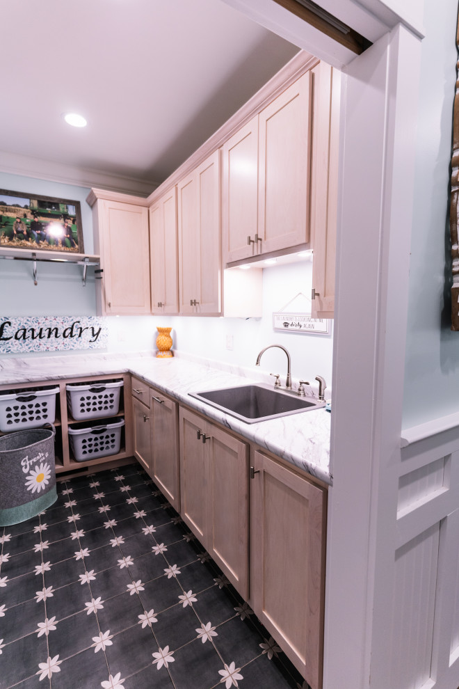 Photo of a small transitional utility room in Other with an utility sink, shaker cabinets, light wood cabinets, laminate benchtops, blue walls, ceramic floors, a side-by-side washer and dryer, multi-coloured floor and white benchtop.