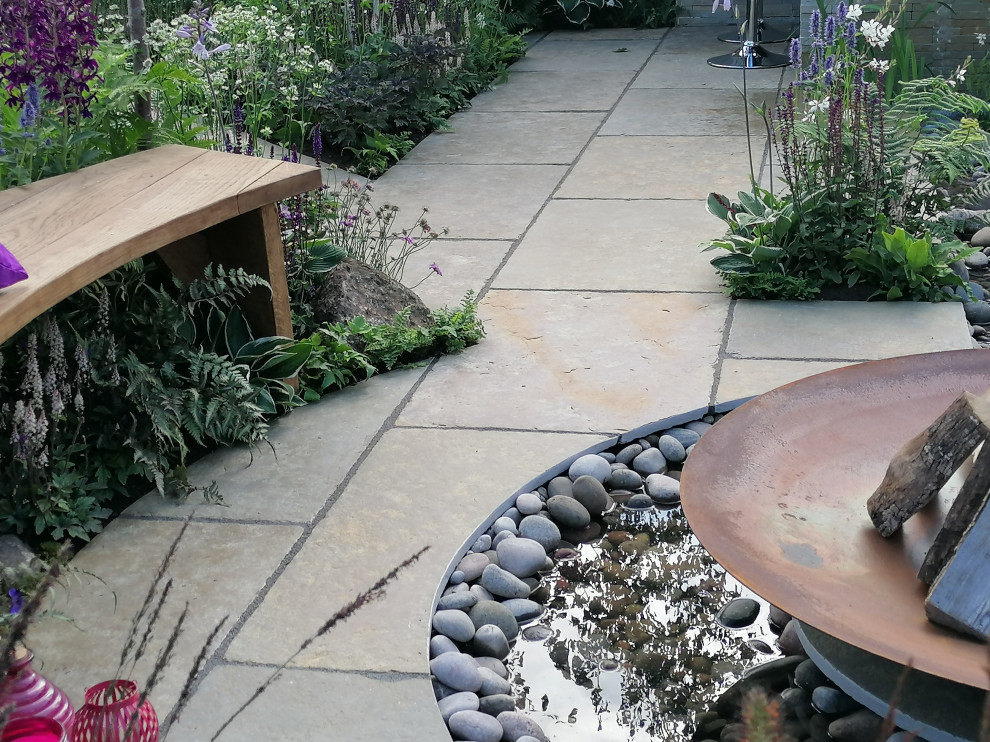 This is an example of a rustic back garden in West Midlands with natural stone paving.