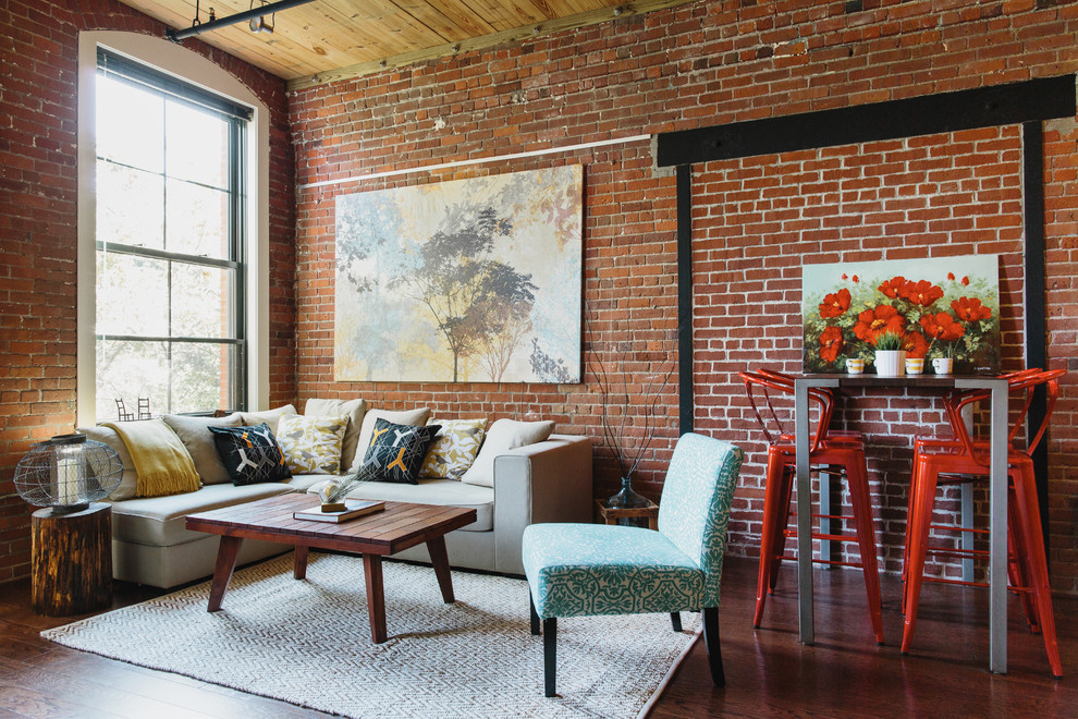 Photo of an industrial open concept living room in New York with red walls and dark hardwood floors.