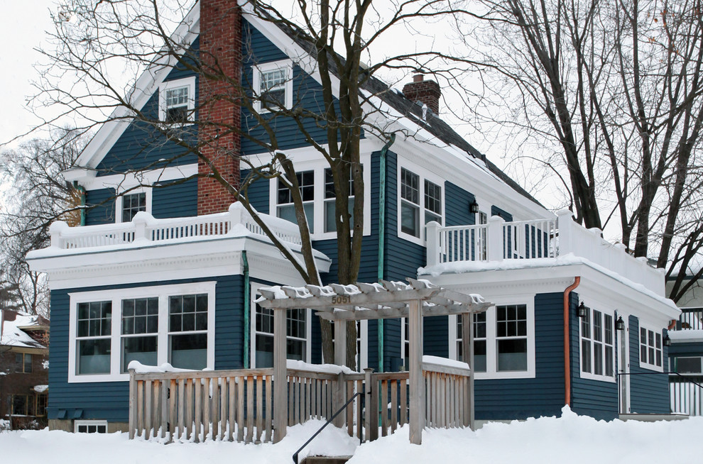 Photo of a large traditional two-storey blue house exterior in Minneapolis with wood siding, a gable roof and a shingle roof.
