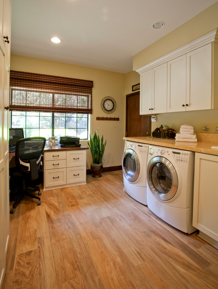 Photo of a mid-sized transitional galley utility room in Los Angeles with a drop-in sink, shaker cabinets, white cabinets, limestone benchtops, porcelain floors, a side-by-side washer and dryer and beige walls.