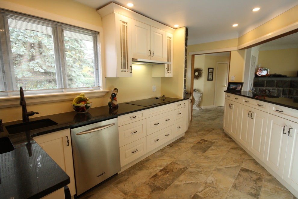 Enclosed kitchen - small transitional porcelain tile enclosed kitchen idea in Ottawa with an undermount sink, raised-panel cabinets, white cabinets, granite countertops and stainless steel appliances