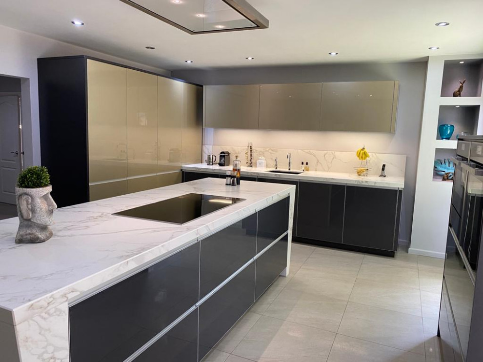 Design ideas for a medium sized contemporary grey and white galley kitchen in Manchester with a submerged sink, glass-front cabinets, grey cabinets, quartz worktops, stone slab splashback, stainless steel appliances, porcelain flooring, an island, beige floors and white worktops.