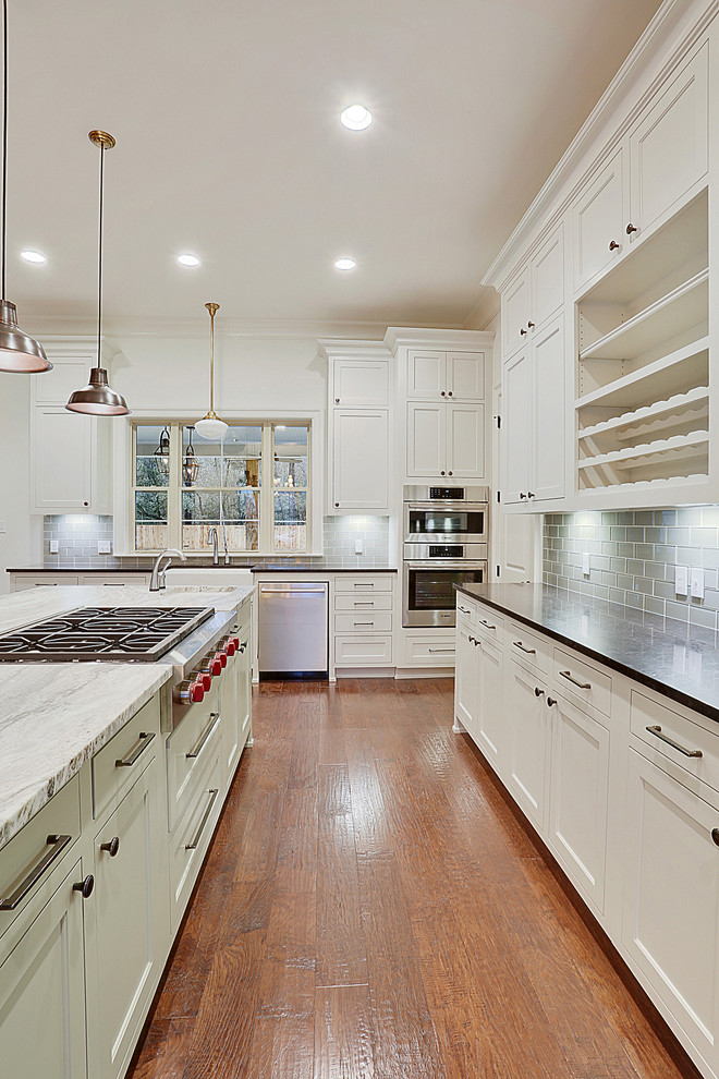 Large transitional l-shaped medium tone wood floor open concept kitchen photo in New Orleans with a farmhouse sink, shaker cabinets, white cabinets and an island