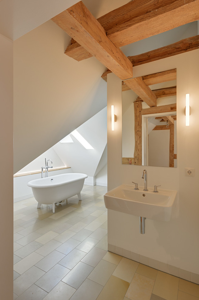 Design ideas for a large contemporary bathroom in Berlin with a wall-mount sink, a freestanding tub and white walls.