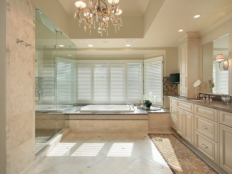 Photo of a large traditional master bathroom in Atlanta with raised-panel cabinets, beige cabinets, a drop-in tub, an alcove shower, beige walls, marble benchtops, beige floor, a hinged shower door, beige benchtops, a shower seat, a single vanity, a built-in vanity, recessed and wood walls.