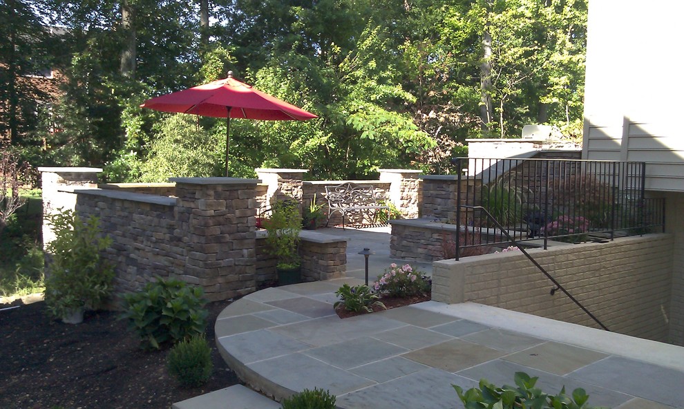 Example of a large transitional backyard stone patio design in DC Metro with a fire pit and no cover