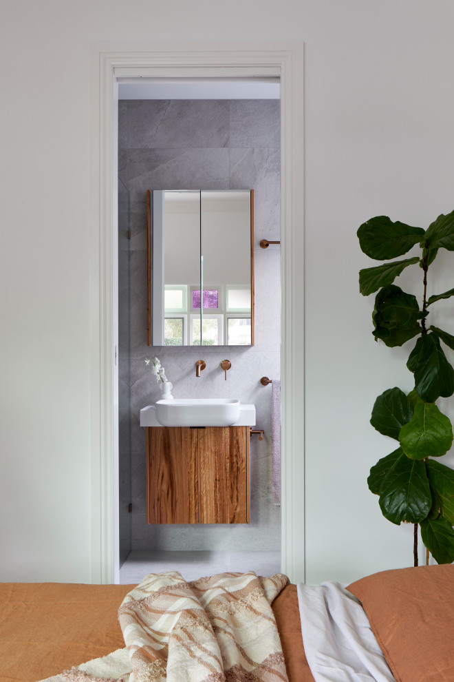 Idéer för ett litet vit badrum, med möbel-liknande, skåp i mörkt trä, en hörndusch, en vägghängd toalettstol, grå kakel, porslinskakel, grå väggar, klinkergolv i porslin, ett integrerad handfat, bänkskiva i kvarts, grått golv och dusch med gångjärnsdörr