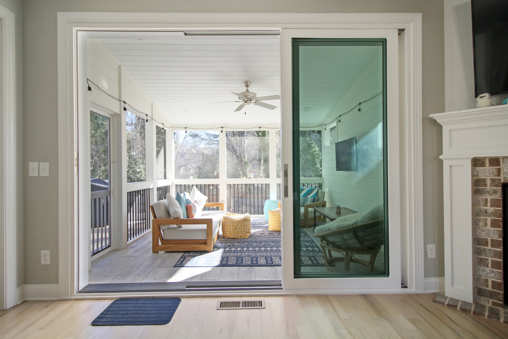 Photo of a mid-sized contemporary backyard screened-in verandah in Atlanta with a roof extension and wood railing.